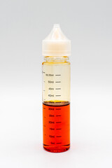 transparent bottle with a white cap half filled with dark liquid on a light background, isolate