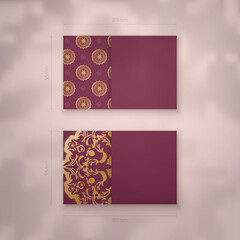 Business card template in burgundy color with luxurious gold pattern for your business.