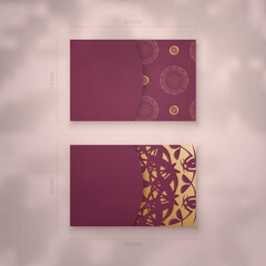 Business card template in burgundy color with luxurious gold pattern for your contacts.