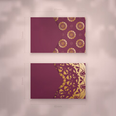 Business card template in burgundy color with luxurious gold pattern for your personality.