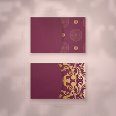 Business card template in burgundy color with vintage gold ornaments for your contacts.
