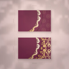 Business card template in burgundy color with vintage gold pattern for your contacts.