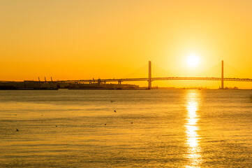 Fototapeta na wymiar 夜明けの横浜ベイブリッジと朝日が反射する海