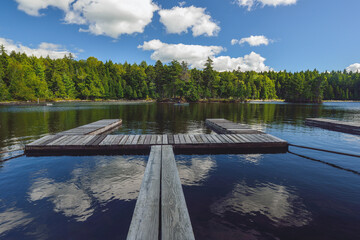 Fototapeta na wymiar Calm Lake waters and puffy clouds in Maine