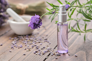 Spray bottle of lavender essential oil. Scented lavender water, serum, flavored water. Lavender flowers on background. Aromatherapy. Natural cosmetic beauty care product. Alternative herbal medicine. - obrazy, fototapety, plakaty