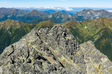 The rocky ridge of the High Tatras against the grassy peaks of the Western Tatras.