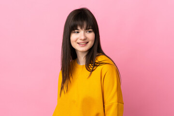 Fototapeta premium Young Ukrainian woman isolated on pink background looking to the side and smiling