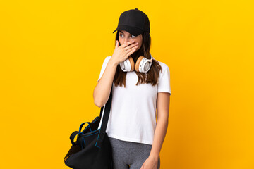 Obraz premium Young sport woman with sport bag isolated on yellow background doing surprise gesture while looking to the side