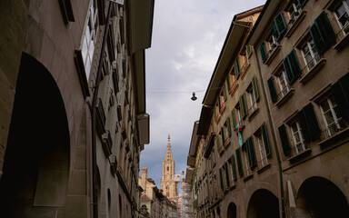 Travel to Switzerland. Berner Münster cathedral with amazing architecture tower photographed during a cloudy morning. Landmark of this city from Bern.