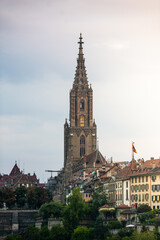 Fototapeta premium Travel to Switzerland. Berner Münster cathedral with amazing architecture tower photographed during a cloudy morning. Landmark of this city from Bern.