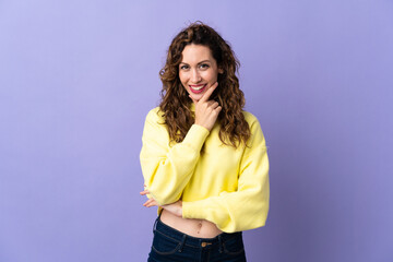 Fototapeta premium Young caucasian woman isolated on purple background happy and smiling