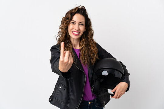 Young caucasian woman holding a motorcycle helmet doing coming gesture