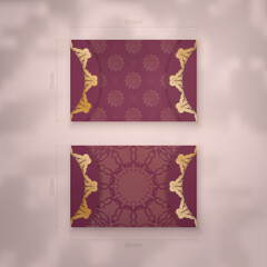 Presentable burgundy business card with abstract gold ornament for your business.