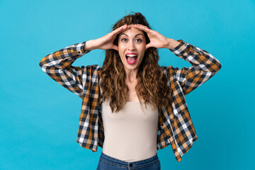 Young caucasian woman isolated on blue background with surprise expression