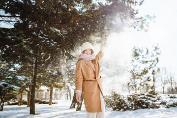 Happy woman in winter style clothes walking in the snowy forest. Nature, holidays, rest, travel concept.