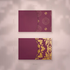 Presentable burgundy business card with abstract gold pattern for your contacts.