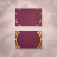 Presentable burgundy business card with gold mandala ornaments for your brand.