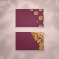 Presentable burgundy business card with Greek gold pattern for your brand.