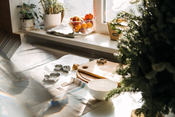 Products and ingredients on kitchen table ready for making Christmas gingerbread. Lifestyle still life Making Christmas gingerbread at home. Ingredients, bakeware, dough rolling pin and utensils