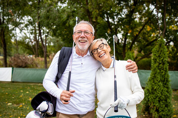 Portrait of smiling senior people with golf equipment ready for training and recreation.
