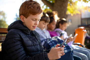 Group of children using their smart phones texting and surfing internet.