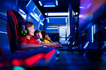 Group of children gamers playing computer video games in game room. Entertaining industry and...