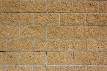 Beige wall tiles imitating brickwork. Modern finishing material. Gray facade facing tiles, imitating a brick. Background texture. Exterior facade decoration close-up
