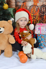 Cute little girl in Santa Claus hat with Christmas presents