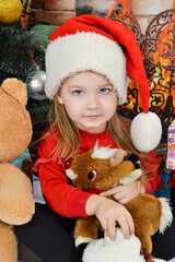 Cute little girl in Santa Claus hat with Christmas presents