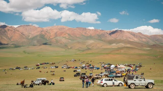 People gather for the traditional Naadam Festival in West Mongolia, dolly right time lapse sequence. The festival is held throughout the country during midsummer in various outdoor locations.