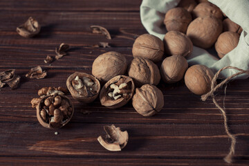Fototapeta na wymiar walnuts in a cotton bag on an old wooden table still life