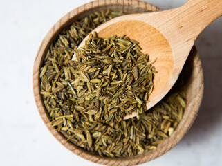 Cumin or cumin in wooden spoon isolated on light concrete background close up