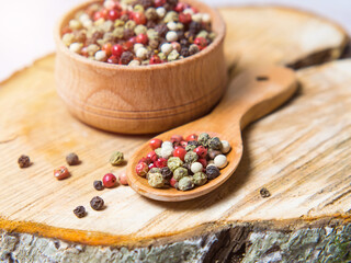 Pepper mix. Black, red, green, white peppercorns spices, Mix of different peppers in a wooden spoon
