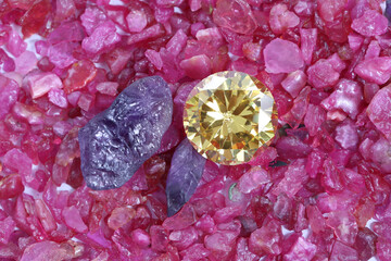 yellow sapphire diamond on placed on a pile of raw ruby rough gemstone..colorful raw stone...