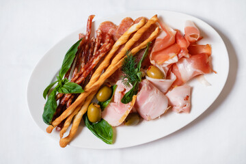 Assortment of canapes with meat. Banquet service. catering food, snacks with cheese, jamon, prosciutto and fruit. Snacks for buffet at the reception. Decorated catering banquet menu.