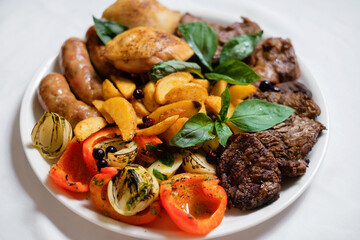 Meat with grilled potatoes and vegetables. BBQ catering.