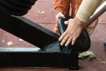 A man and a child on the machine work together to adjust weights and discs. Active, healthy walks on the city streets