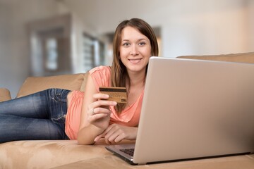 Naklejka premium Happy young woman shopping online, paying bills with credit card