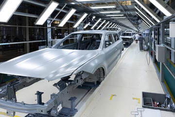 Car bodies are on assembly line. Factory for production of cars. Modern automotive industry