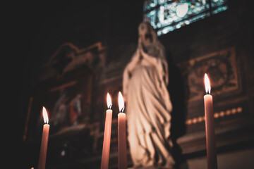 Candles lit in the church with the altar and christian icons in the background. Roman Catholic...