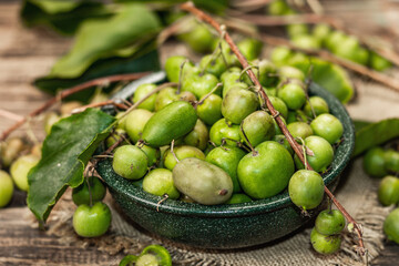 Harvest of ripe Actinidia arguta kiwi in a ceramic bowl