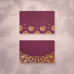 Visiting business card in burgundy color with Indian gold ornaments for your brand.