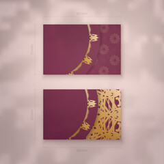 Visiting business card in burgundy color with Indian gold ornaments for your business.
