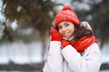 Young woman in winter style clothes against the backdrop of snowy forest. Nature, holidays, rest, travel concept.