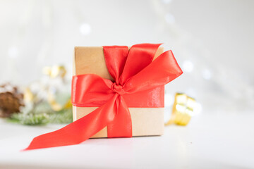 beautiful festive surprise gift box with a red bow on a bokeh background and near the Christmas tree for new year and valentine's day