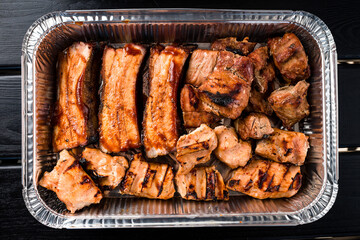 set of grilled ribs and BBQ meat in a delivery box