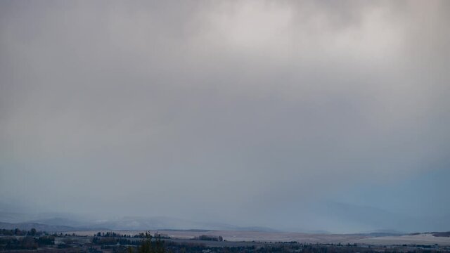 Snowy sky. Couldy weather atmosphere winter cool air, windy blow clouds traveling above snowy mountains. White snow on top of the Rocky Mountain. Aerial view of northern American. Panoramic Canada 4k
