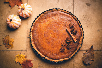 American pumpkin pie with cinnamon on tile background, top view