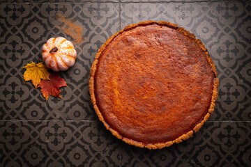 American pumpkin pie with cinnamon on dark background, top view