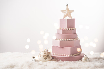 Christmas tree made of pink geometric shapes and podiums on white background